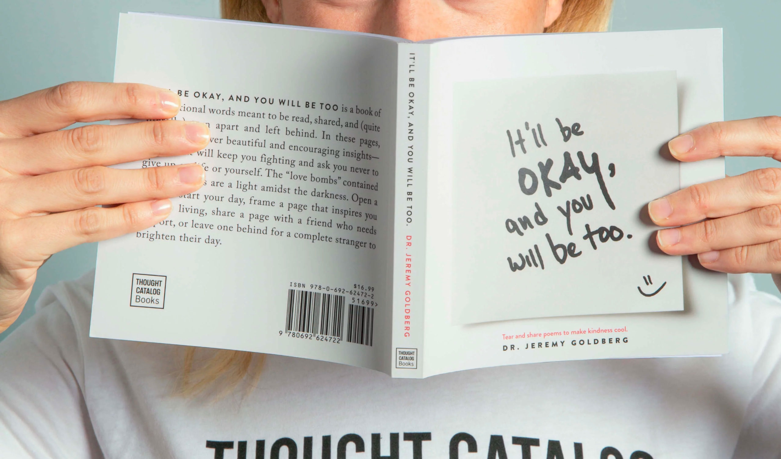 person holding a book in front of their face