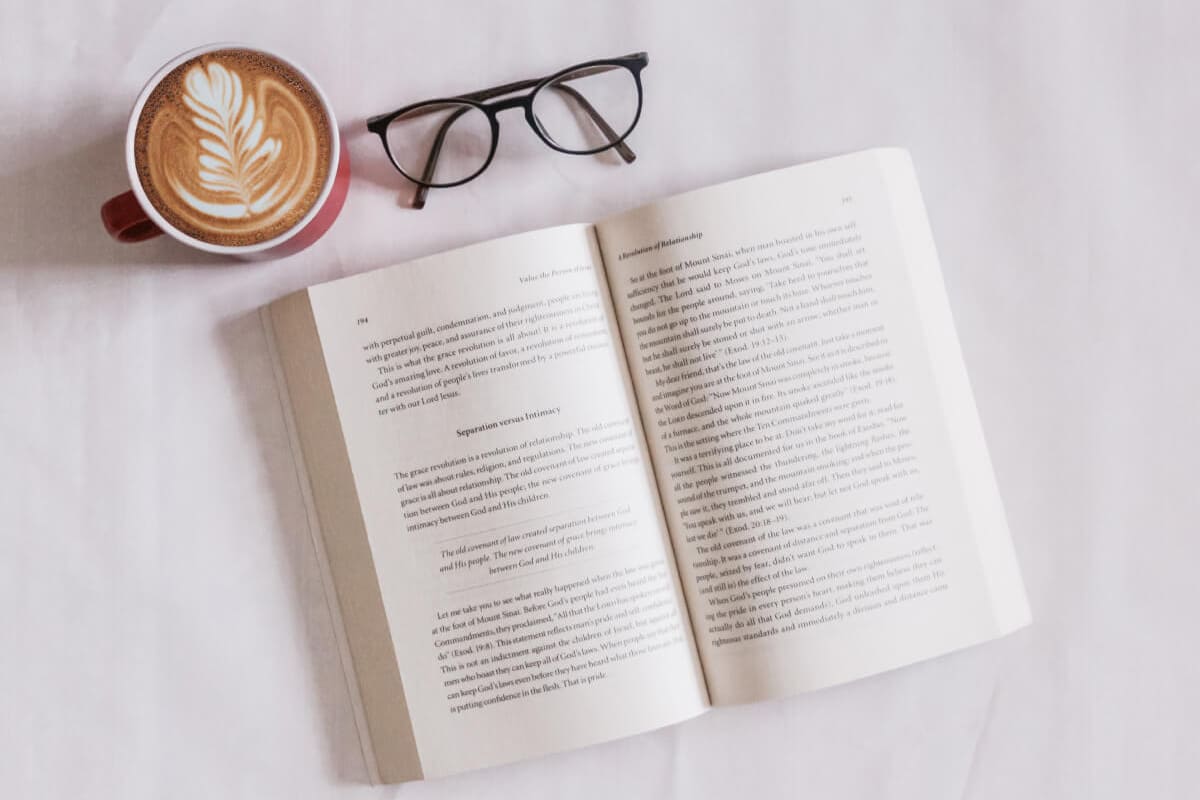 open book and glasses with coffee